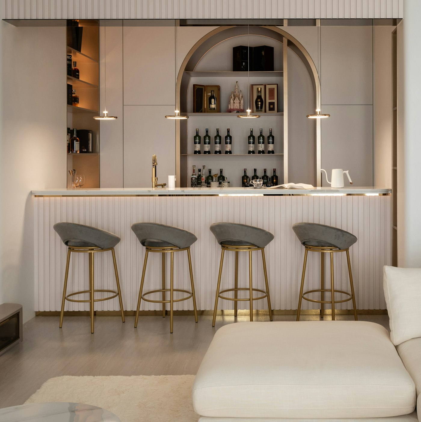 Finished basement lounge with an arched bar and warm lighting
