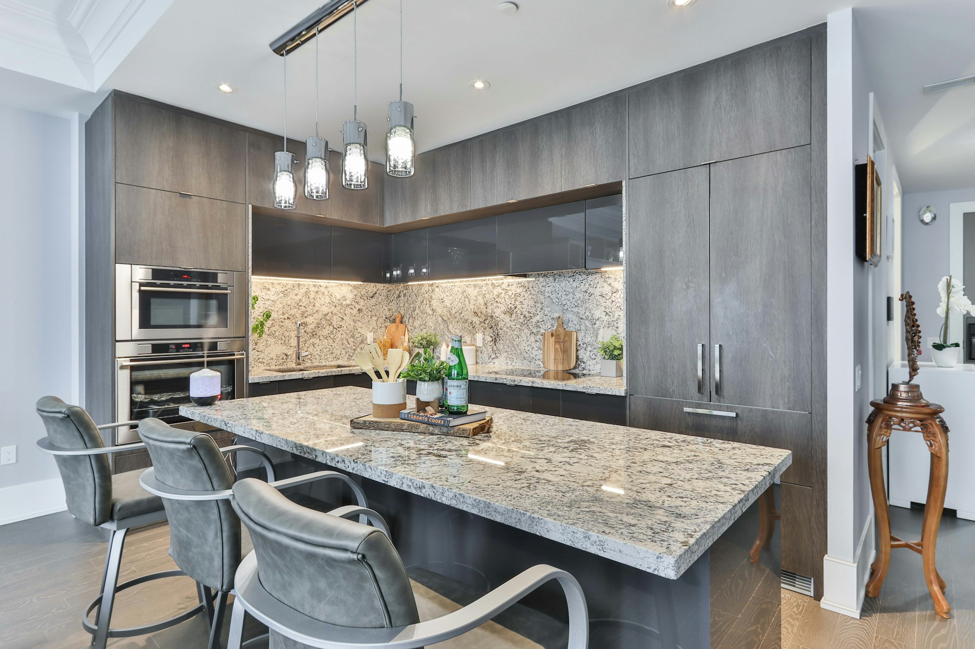A completed JANKO kitchen remodel with a stone waterfall island and custom cabinetry
